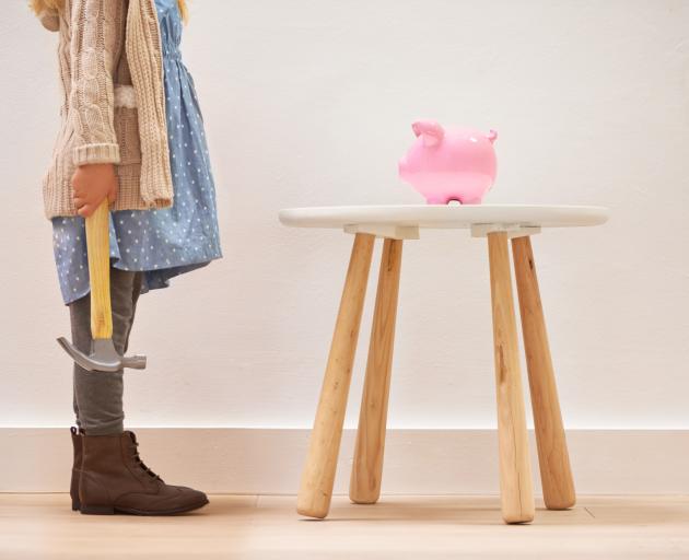 child with hammer and piggybank