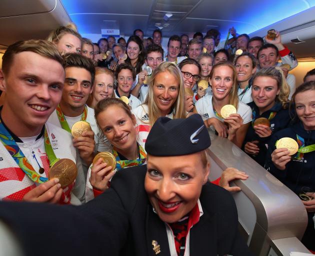 Gold medallists of the Great Britain team pose for a selfie with a member of British Airways cabin crew before flying home from Rio. Photo: Getty Images 