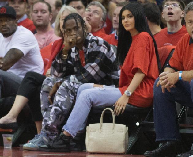 Travis Scott (centre) and Kylie Jenner at a basketball game in Texas last year. Photo: Getty...