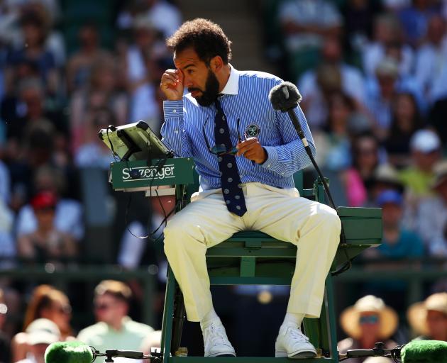 Chair umpire Kader Nouni is pestered by flying ants during a second round match on Wednesday....