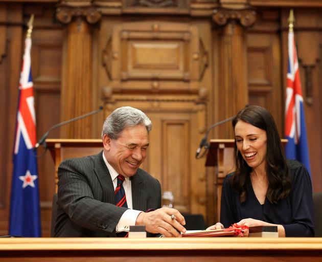 Prime Minister-elect Jacinda Ardern signs coalition agreement with NZ First leader Winston Peters at Parliament yesterday. Photo: Getty Images