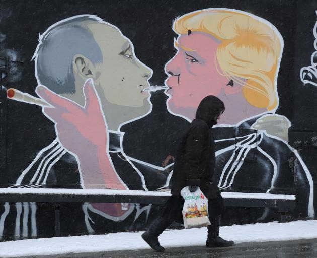 A mural depicts US President Donald Trump (right) blowing marijuana smoke into the mouth of...