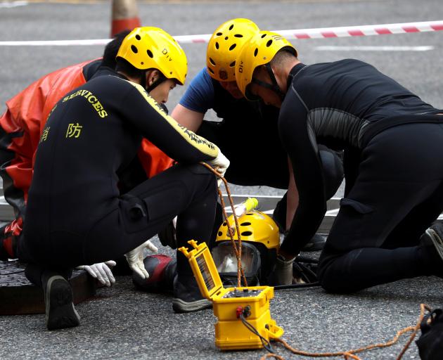 A rescue diver from the Fire Service department enters the sewage system to search anti...