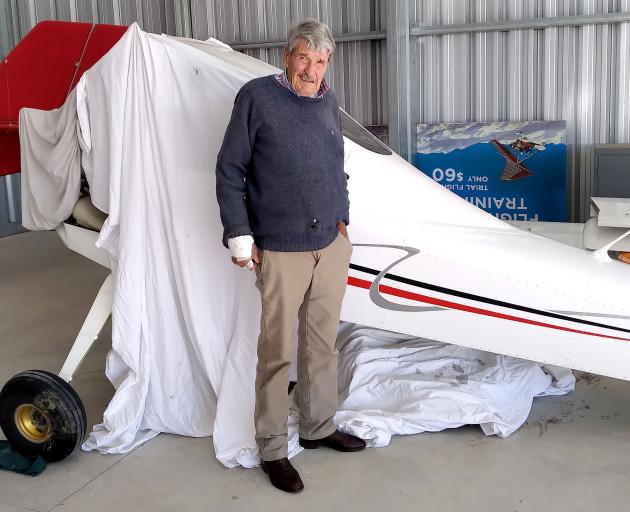 Alan Macdonald with the wrecked aircraft. Photo: Geoff Sloan