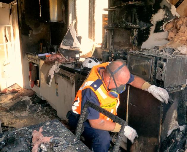 Fire Investigators inside the house. Photo: Geoff Sloan