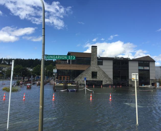 Water laps close to businesses on the waterfront in Wanaka late on Saturday afternoon. Photo:...