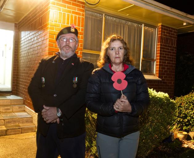 John Cosgrove stands with his wife Kathleen in front of their house to commemorate Anzac Day....