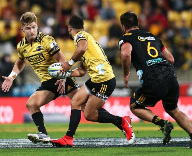 Matt Proctor of the Hurricanes passes to Jordie Barrett during their clash with the Chiefs in...