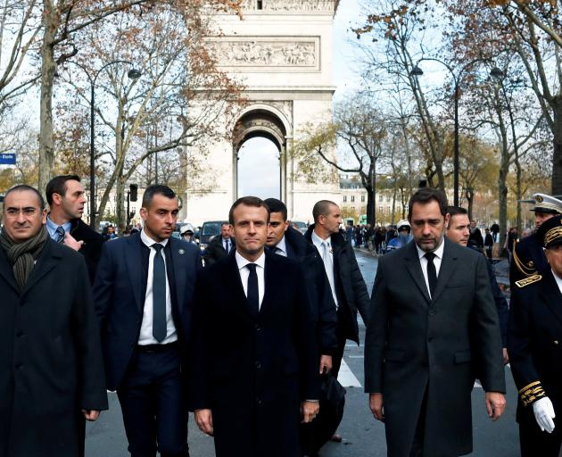Emmanuel Macron (centre) visits the riot-battered neighbourhood around the Arc de Triomphe in...