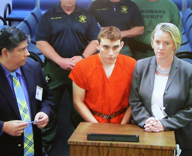 Nikolas Cruz (centre) is accused of opening fire with an AR-15 semiautomatic rifle, killing 14...