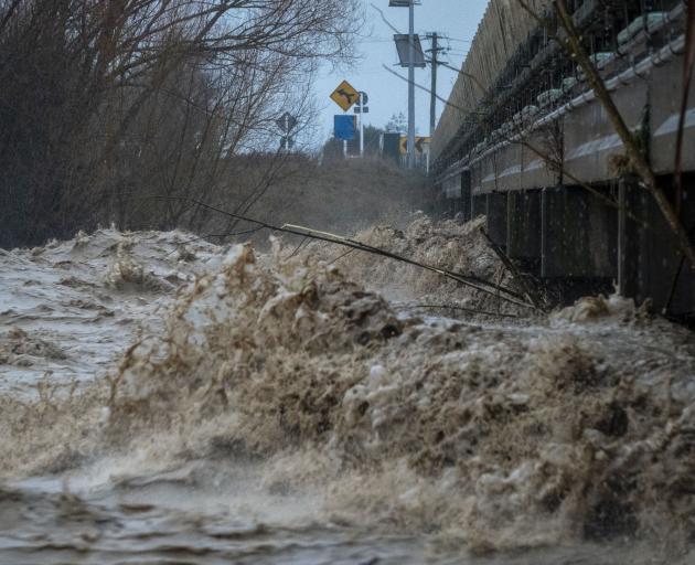 Debris-laden water spews under the Orari Bridge, in South Canterbury, 
yesterday. PHOTO: BRIAN HIGH