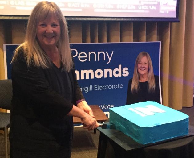 Penny Simmonds cuts a National party cake in relief tonight. Photo: Luisa Girao