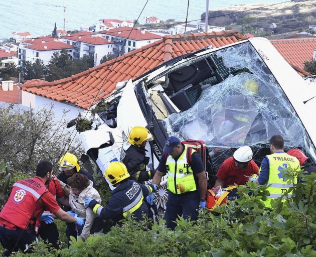 Injured passengers are taken from the bus after the crash on Madeira Island. Photo: Global...