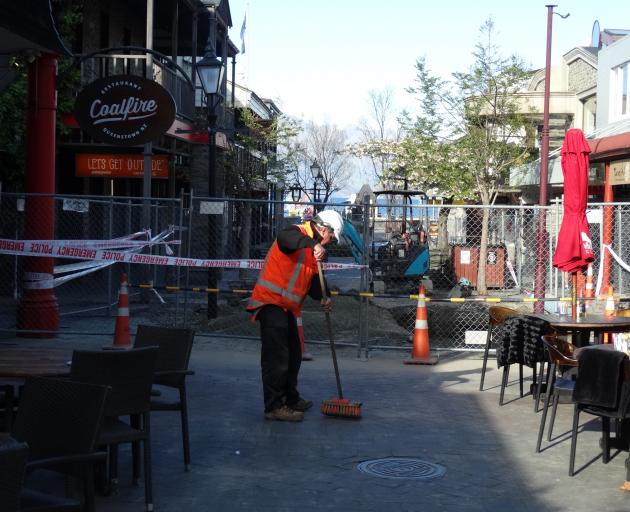 A contractor cleaning silt in Queenstown Mall this morning. Photo: Paul Taylor