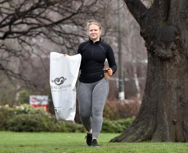 Our Seas Our Future volunteer Emily Colquhoun picks up cigarette butts and rubbish in Dunedin...