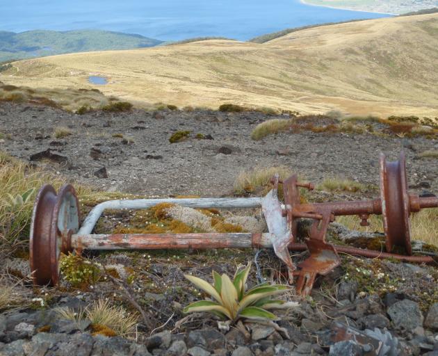 A rusty rope tow pulley is all that is left from a would-be ski field on Mt Luxmore. The roof of...