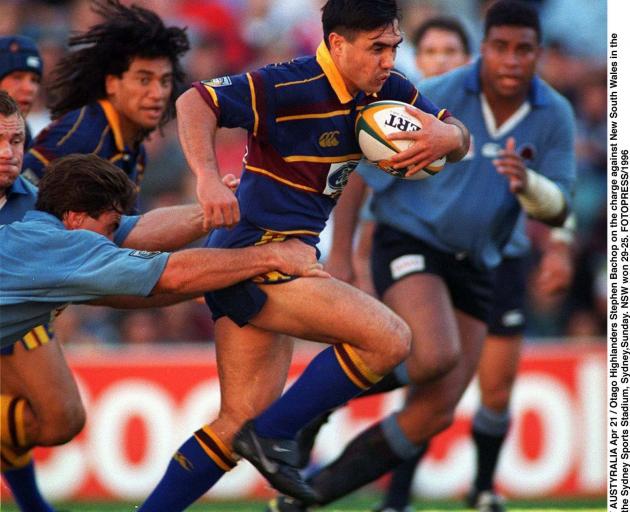 Highlanders first five-eighth Stephen Bachop busts through the attempted tackle of ...