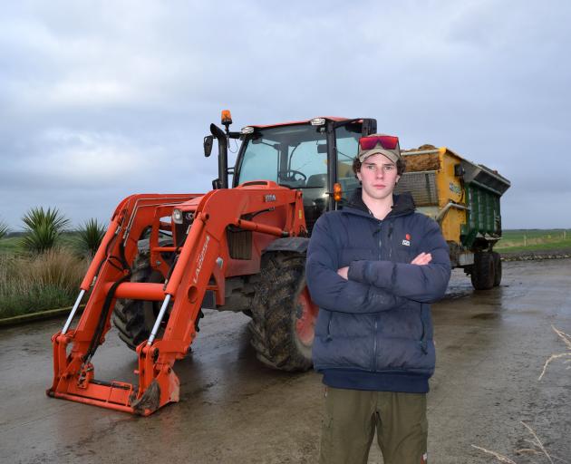 Slade Koenig (15) and a tractor and a silage wagon used to feed cows in the sawdust barn on his...