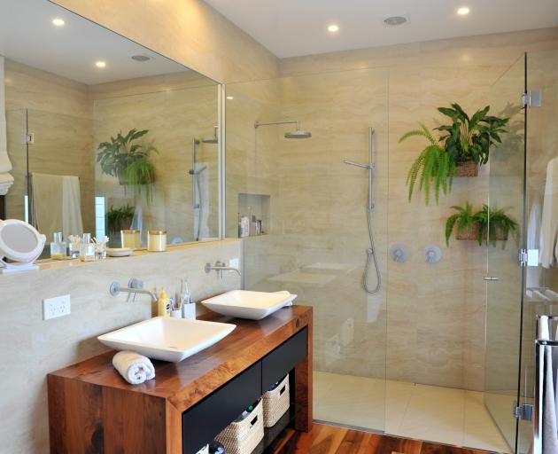 The en suite bathroom features a vanity, by Michael Landmann, made from rough-sawn hardware store...