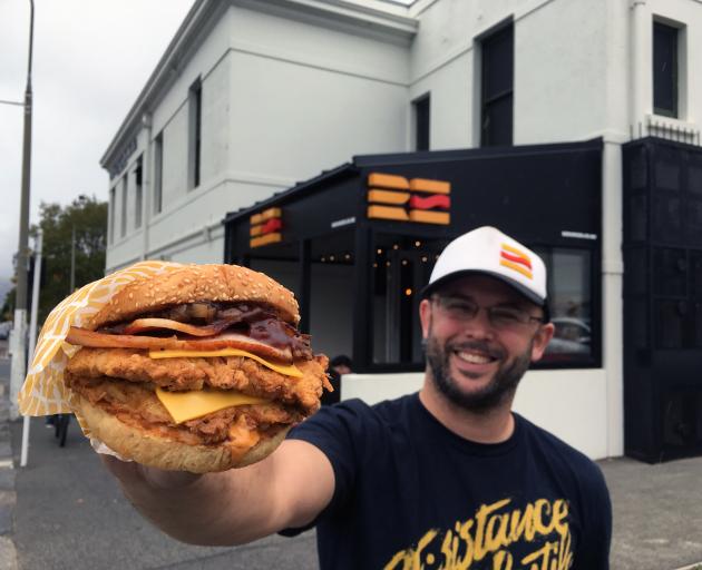 Re:Burger owner Boris Reiber presents one of his creations outside his store in North Dunedin....