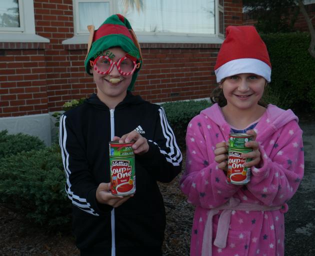 Siblings Alex (11, left) and Darcy (9) Tavendale wait for their cans to be collected during the...