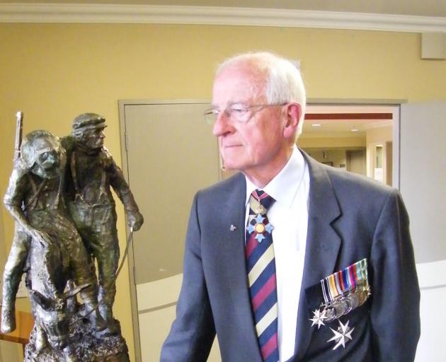 Retired Brigadier Dr Brian McMahon is shown with the bronze statuette he received to mark his...