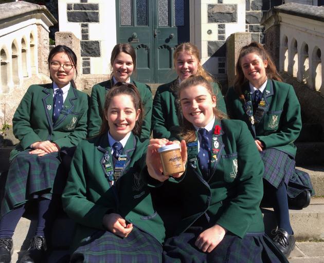 Displaying a jar of almond butter they are selling as part of the Young Enterprise Scheme are...