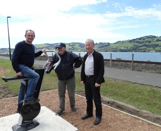 West Harbour Community Board chairman Steve Walker takes an outdoor exercycle for a spin, while landscape architect Mick Reece and Rotary Club of Dunedin representative Neil Lyons look on. PHOTO: BRENDA HARWOOD