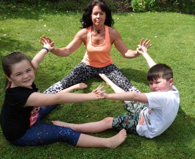 Dunedin yoga practitioner Aaron Kyle (centre) works on a group exercise with yoga beginners Maddy...