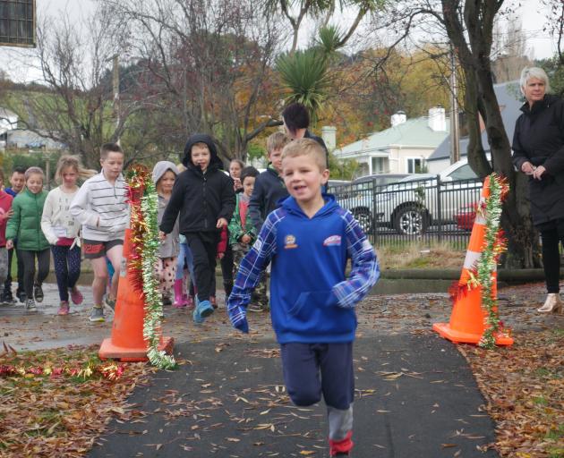 Sawyers Bay School pupil Eli Olsen (7) leads the way as children start to run around the track....