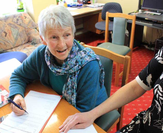 SuperGran’s Dunedin manager Marie Sutherland prepares some life skills information for a client...