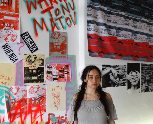 Dunedin artist Teah Paterson is flanked by her own work (right), focusing on the mana wahine...