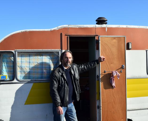 Traveller Beck Ritchie relaxes outside his 1964 caravan in the Ocean View Recreation Reserve...