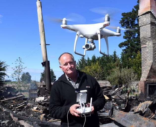 Stephen Jaquiery uses a drone to shoot video of a house fire aftermath at Mt Stoker. PHOTO: DAISY...