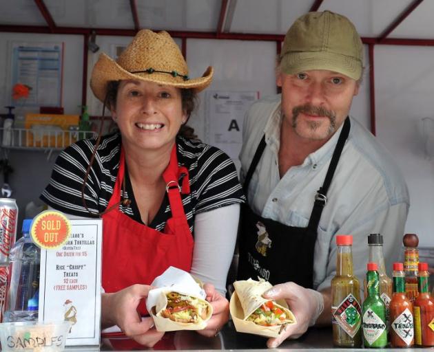 Matt Morgan prepares his special-recipe tacos with slow-cooked pork and beef, while wife Kim chats with a customer in the background. Photo by Craig Baxter. Matt Morgan prepares his special-recipe tacos with slow-cooked pork and beef, while wife Kim chats with a customer in the background. Photo by Craig Baxter.
