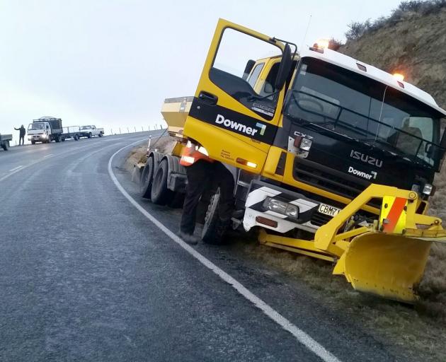 A Downer grit truck sits in a ditch on State Highway 87 between Outram and Sutton yesterday....