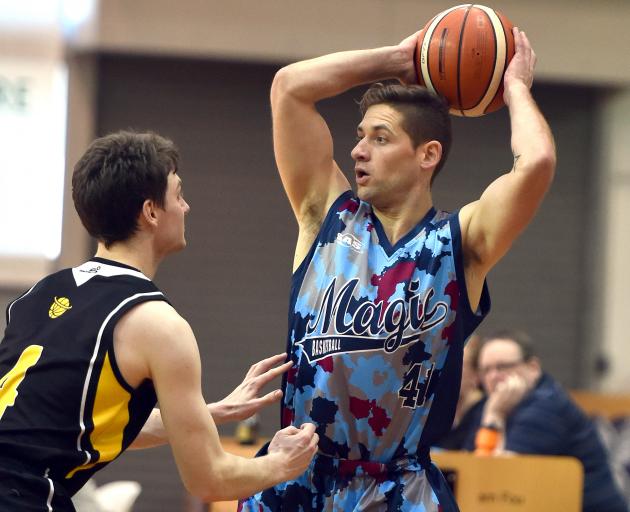 Magic guard Lee Devereaux looks to pass as he is defended by Saints guard James Ross. Photo:...