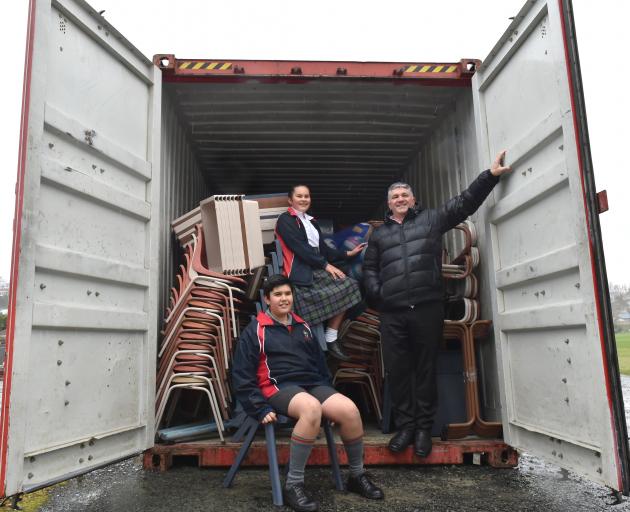 Balmacewen Intermediate pupils (from left) Michael Rietveld (12) and Myah Omipi (13), and principal Andrew Hunter with a shipping container filled with ‘‘second-hand’’ school equipment, bound for Samoa. Photo by Gregor Richardson.