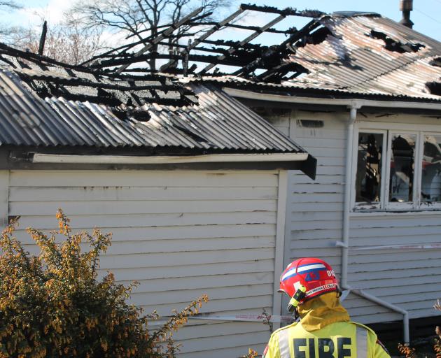 Firefighters mop up after the blaze that engulfed a Wolsley St house in early yesterday morning....