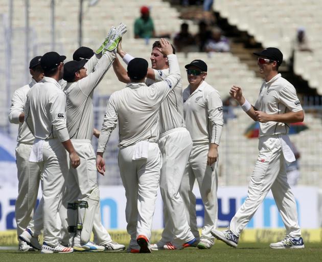 New Zealand's Matt Henry (3rd from right) is congratulated by his teammates after taking the...