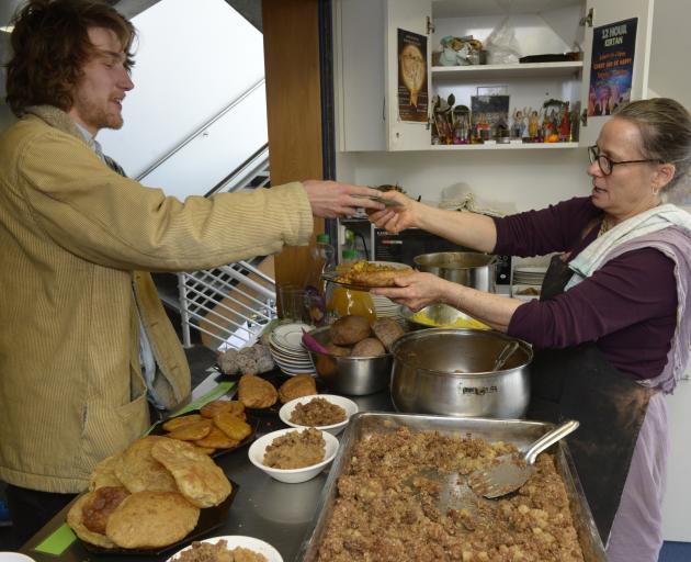 Student Max Gunn receives a plateful of vegetarian goodness from Hare Krishna Jane Beecroft, who...