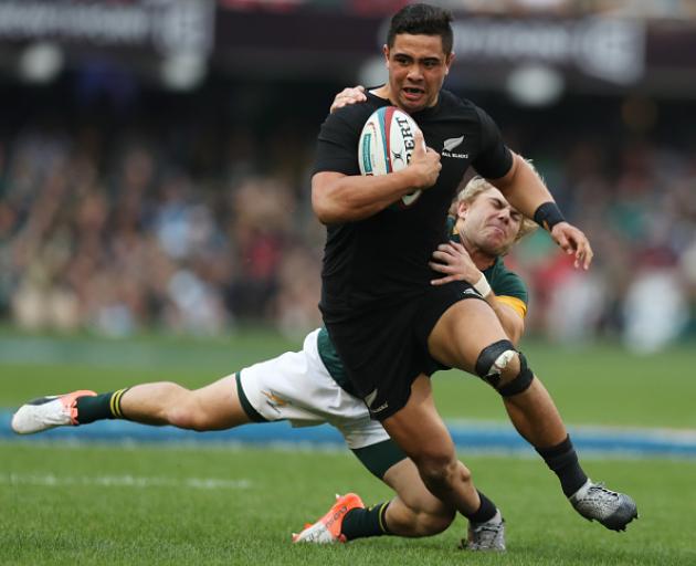 New Zealand's Anton Lienert-Brown tries to break from the tackle of South Africa's Faf de Klerk....