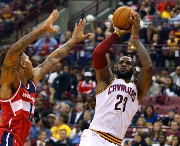 Cavaliers forward LeBron James shoots over Washington Wizards swingman Kelly Oubre during a pre...