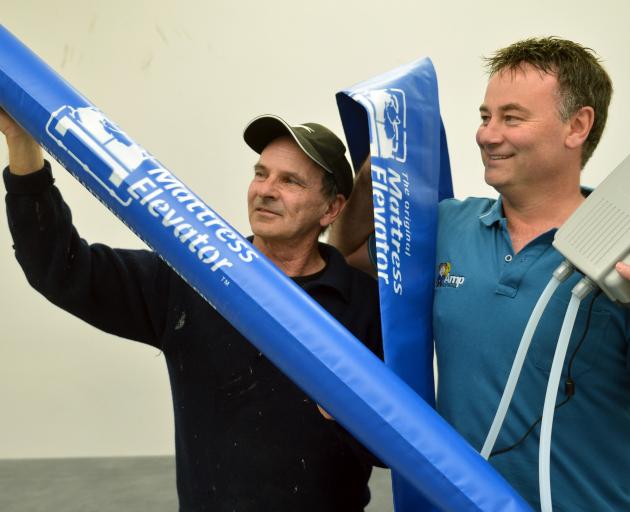 BFW Innovations business partners Larry Burns (left) and Grant Woolford hold up a mattress elevator invented in Dunedin. Photo by Stephen Jaquiery.