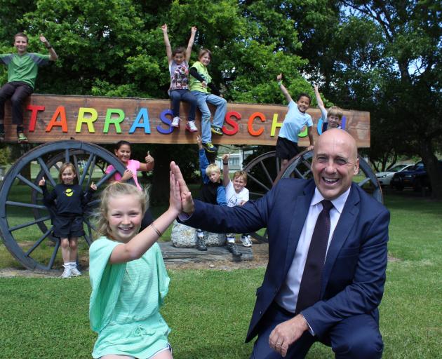 Tarras School pupil Billie Willson (10) high-fives Central Otago Mayor Tim Cadogan yesterday after an announcement the settlement's toilet problems will soon be over, while the school's other pupils celebrate. They are (from left) Jack Willson (13), Aster