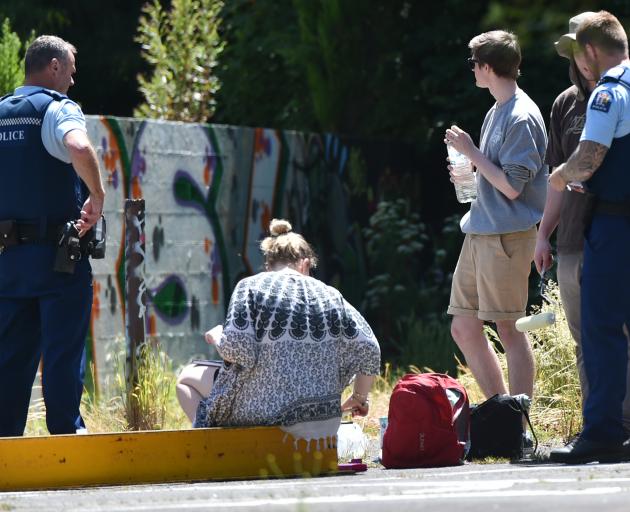 Police speak to a group of young people about painting on a derelict wall at the intersection of Serpentine Ave and Maori Rd yesterday. Photo by Gregor Richardson.