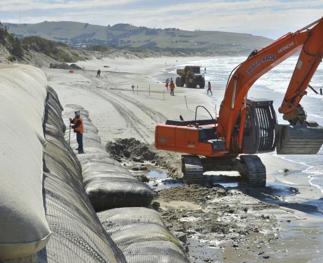 Contractors remove rocks and debris washed up on St Clair Beach during recent severe weather, and deposit truckloads of sand to protect the beach and sand sausages. Photo by Gerard O'Brien.