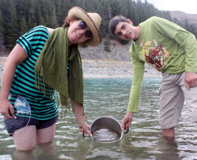 Gathering fresh water from Lake Hawea near the dam yesterday are Lake Hawea residents Pip Harker and Nicholas Rumore (15). Ms Harker has been using the lake or a spring in Wanaka instead of the chlorinated water in the Lake Hawea supply. Photo by Tim Mill