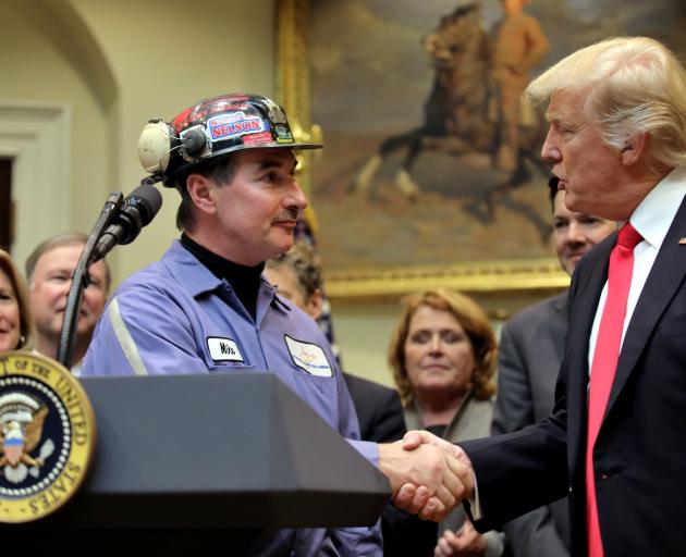 President Donald Trump shakes the hand of a coal miner at a signing ceremony last week to repeal...