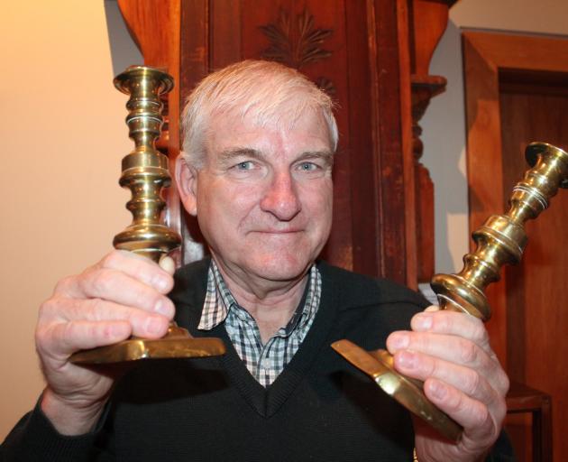 Prof Brian Roberts holds a set of candlestick holders which his ancestors salvaged from the wreck of Surat in 1873 and have been given to the Owaka Museum. Photo by Samuel White.